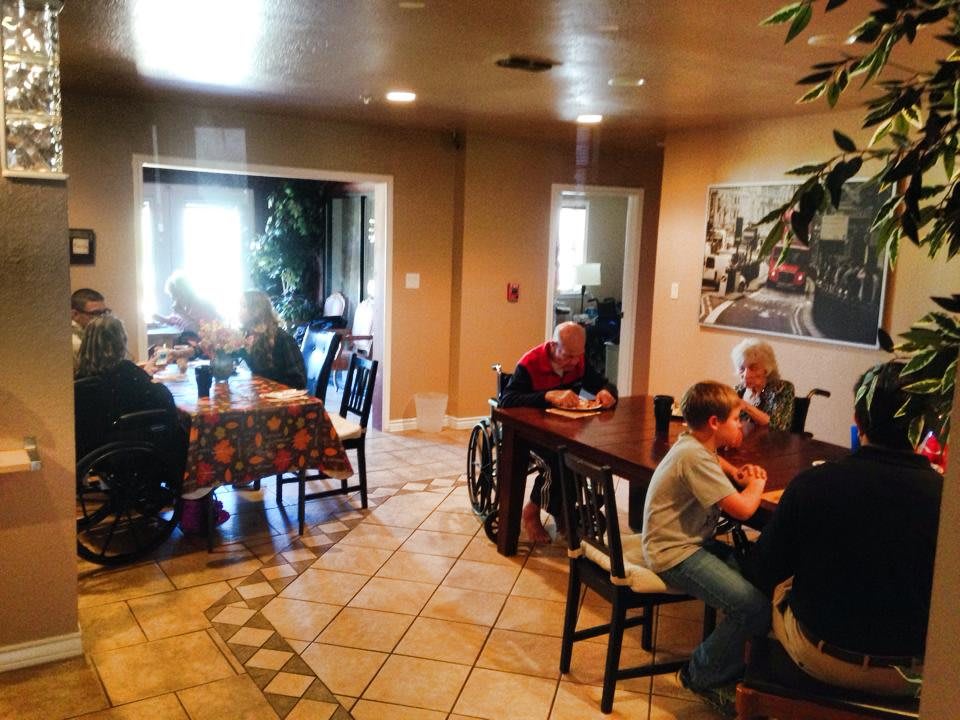 A group of people sitting at tables in a cozy indoor dining area.