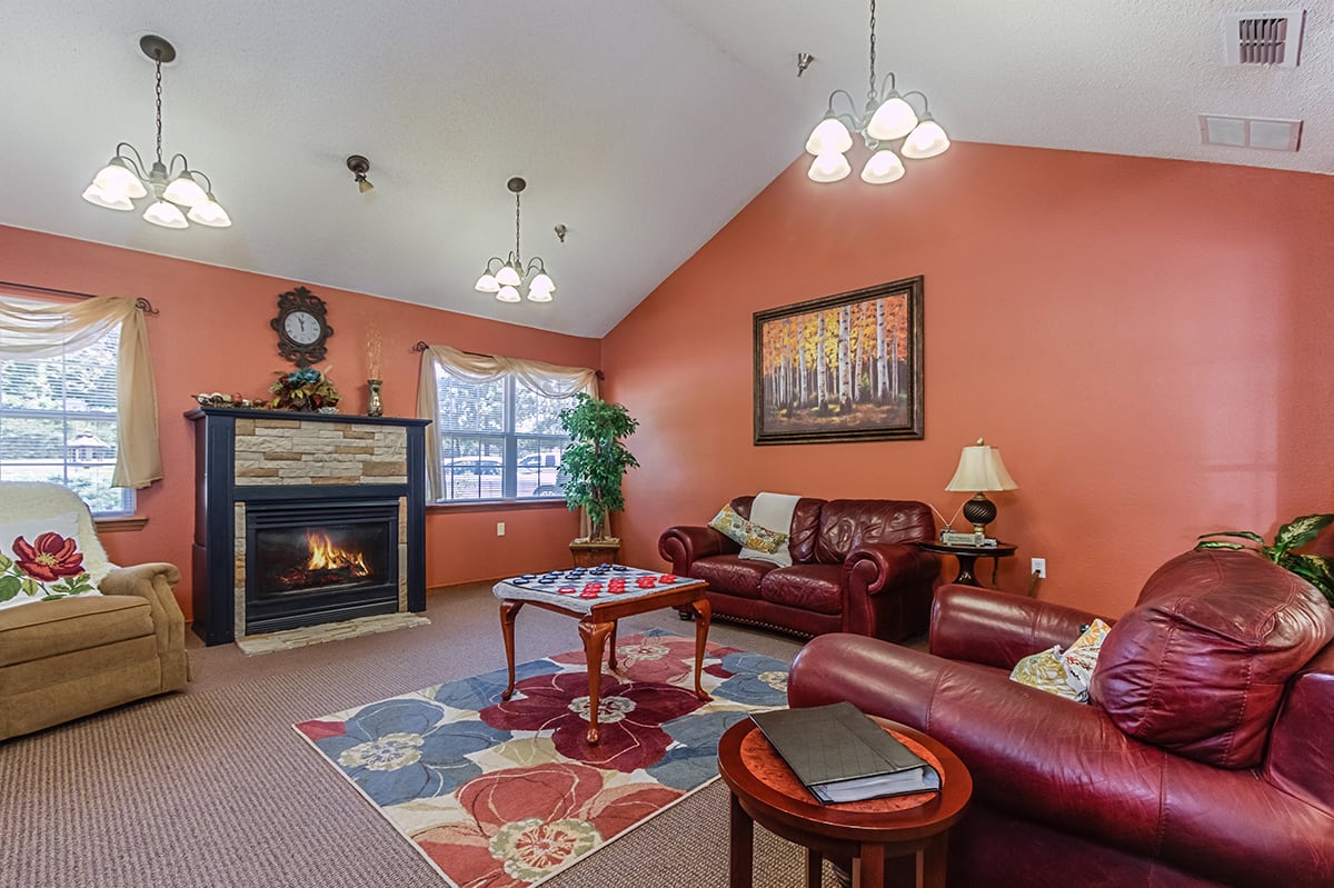 A cozy living room with a fireplace, leather furniture, and warm lighting.