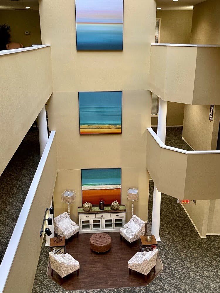 Modern atrium with colorful paintings and a cozy seating area.