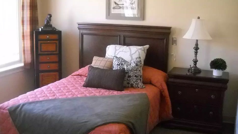 A cozy bedroom with a neatly arranged bed and pillows.