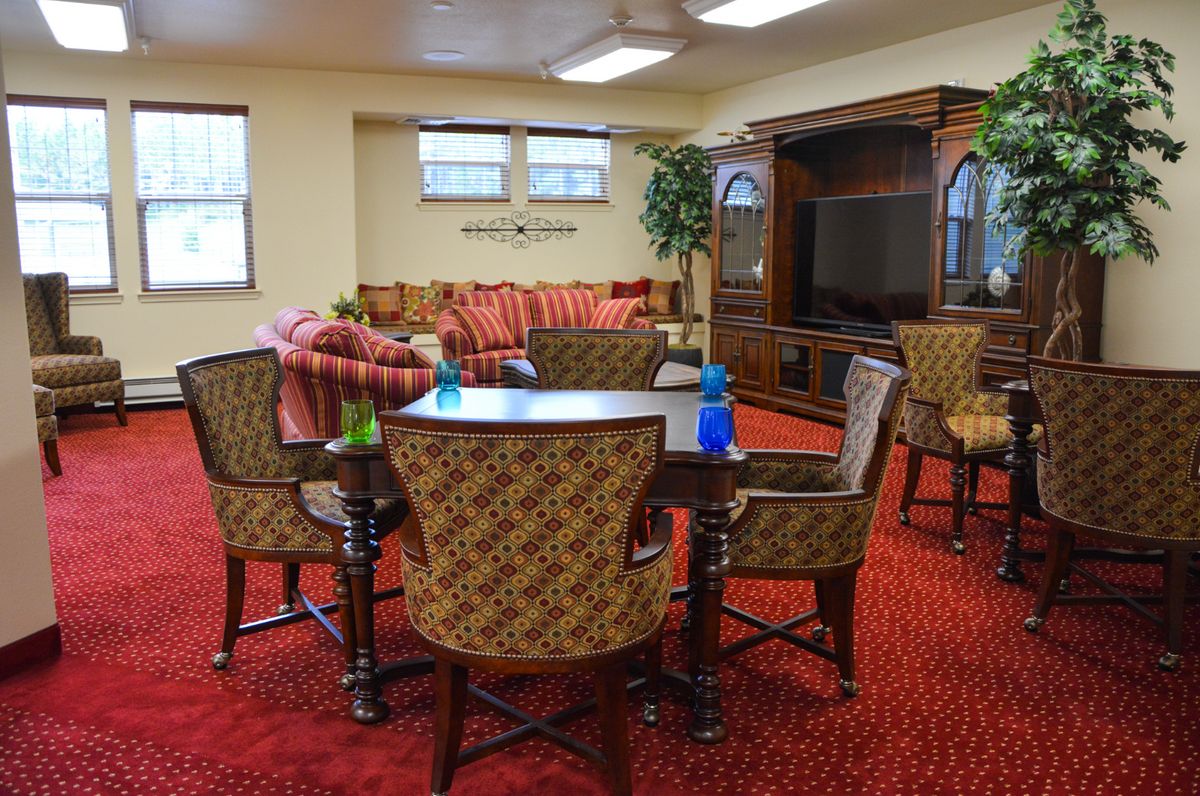 A cozy living room with a seating area, dining table, and entertainment center.