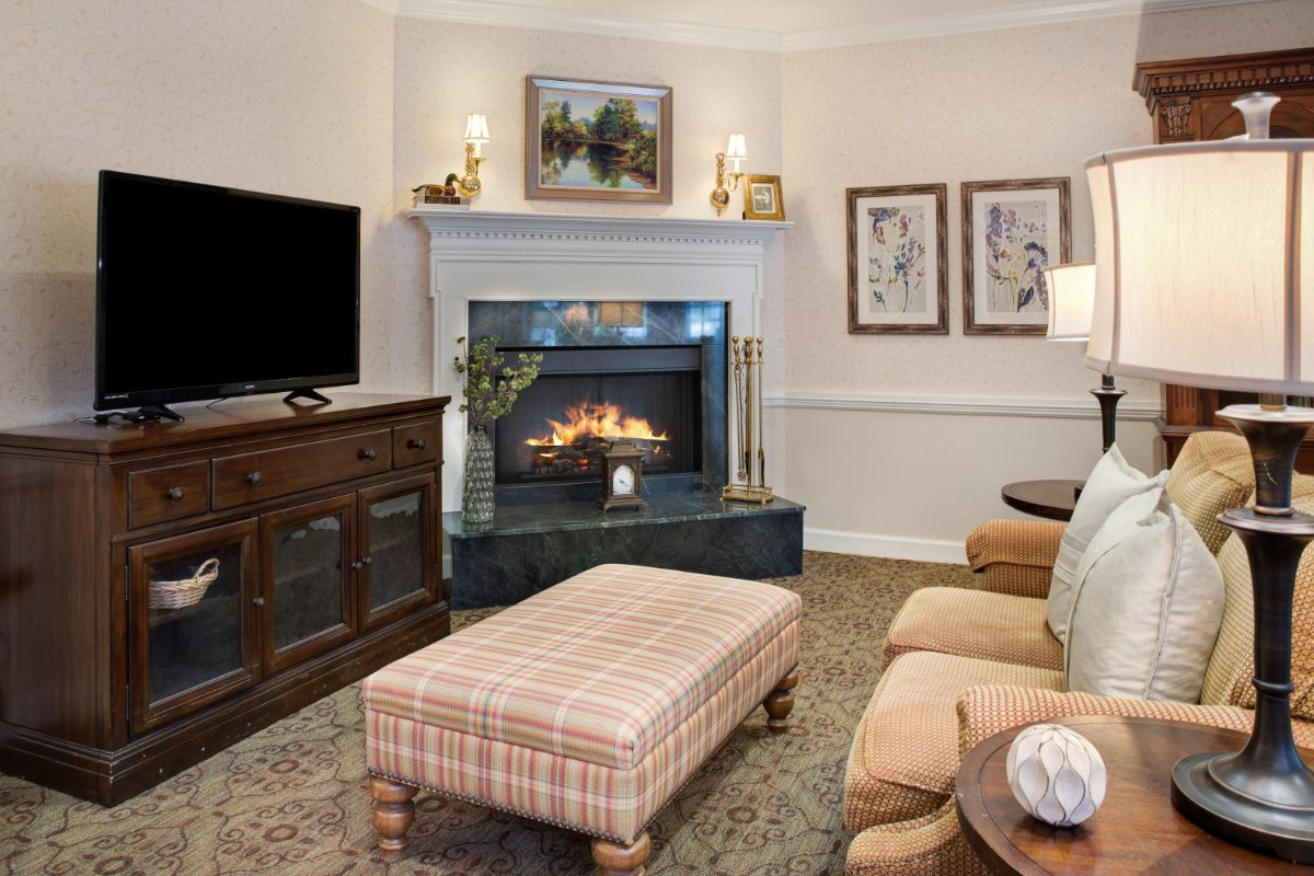 A cozy living room featuring a fireplace, television, and comfortable seating.