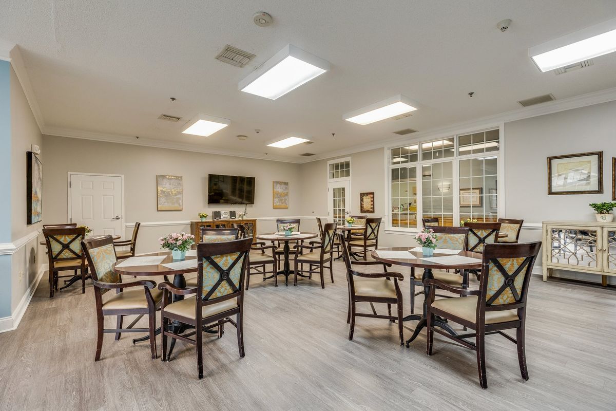 A bright and modern dining area with multiple tables and chairs.