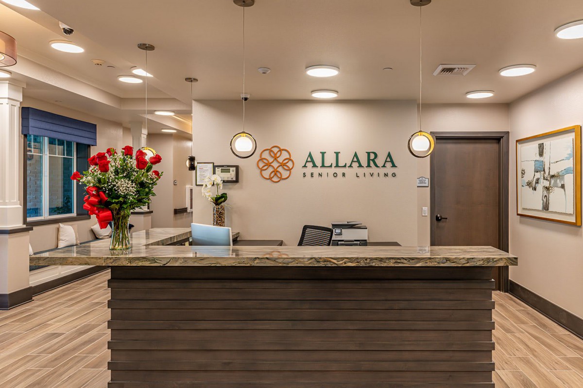 Reception area of an office with a welcoming desk and floral arrangement.