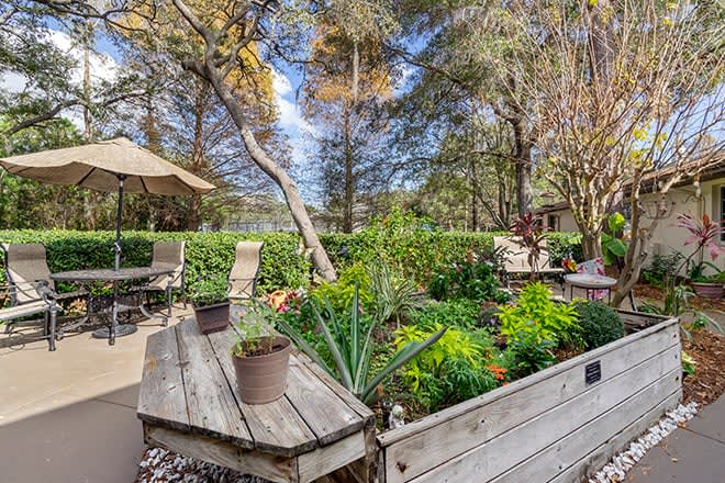 A beautiful garden space with lush greenery and patio seating.
