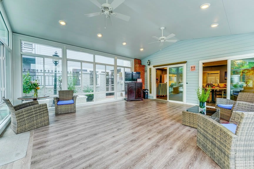 A spacious and well-lit living room with hardwood floors, modern furniture, and large windows.