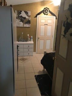 View into a bathroom featuring a sink, cabinet, and bathtub.