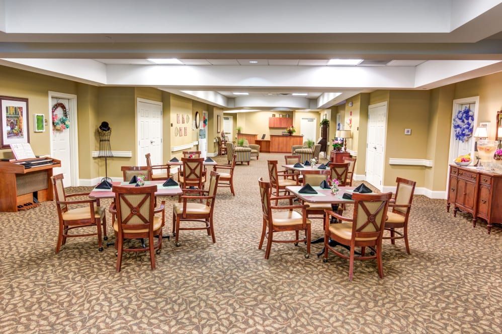 A well-arranged dining room with multiple tables and chairs, featuring a warm and inviting interior.