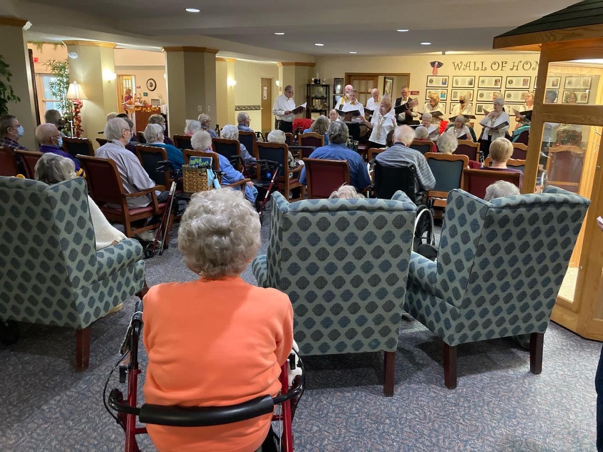 Residents gather in a senior living facility for an indoor concert.