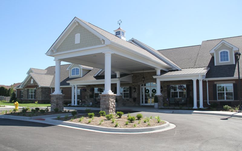 A front view of a commercial building with a covered entrance and landscaped surroundings.