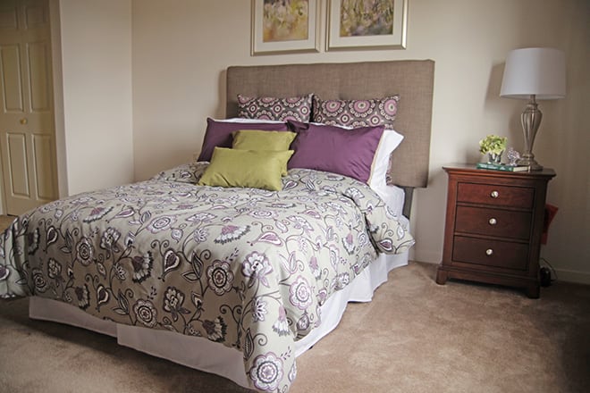 A cozy bedroom with a stylish bedspread and decorative pillows.