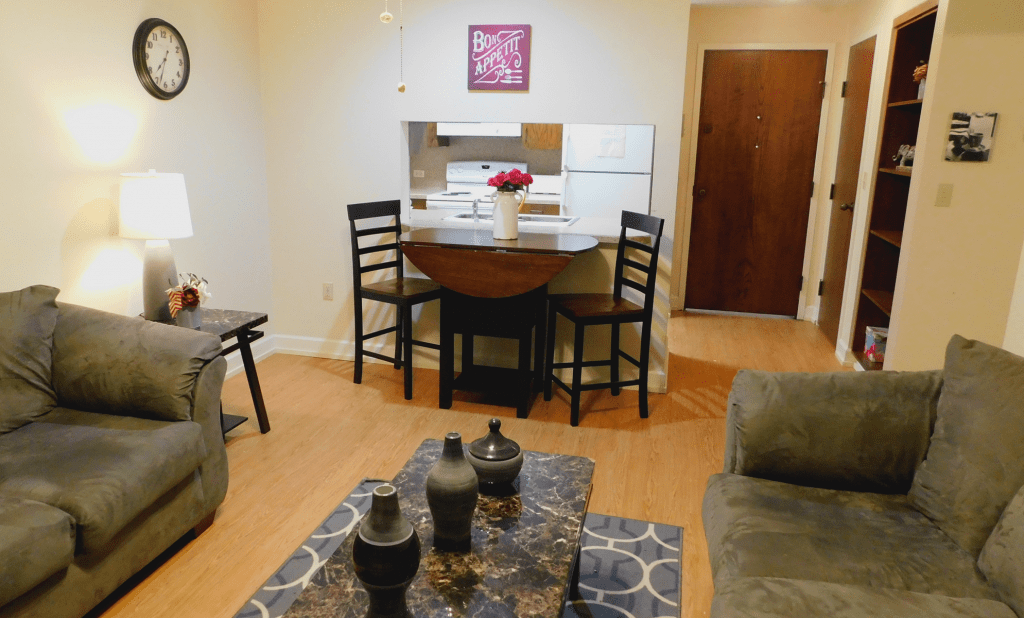 A cozy living and dining area with a small table, chairs, and a couch adjacent to the kitchen.