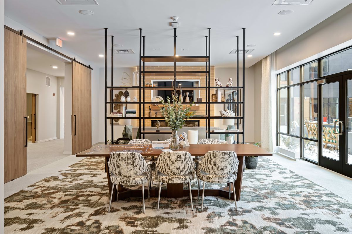 A modern dining area with stylish open shelving and contemporary furnishings.
