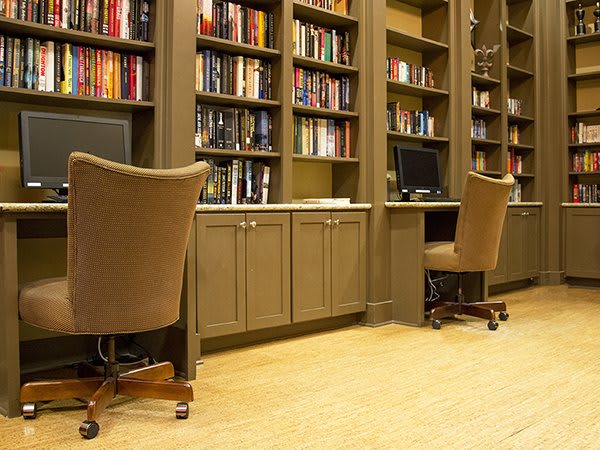 A cozy library space with bookshelves and computer desks.