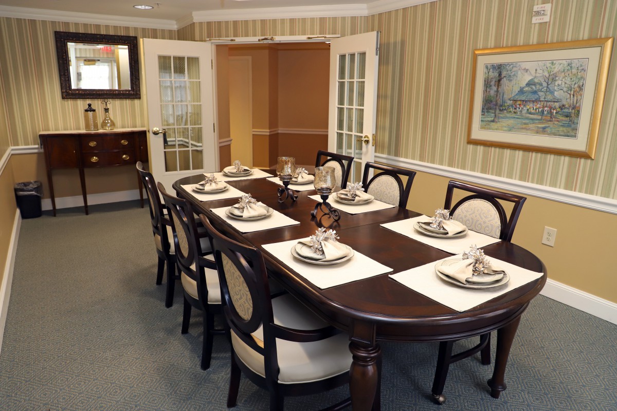 A neatly set dining table with elegant chairs in a well-decorated room.