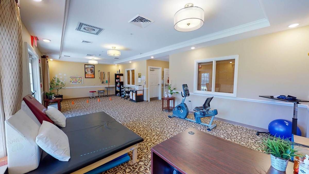 A spacious therapy room with exercise equipment in a healthcare facility.