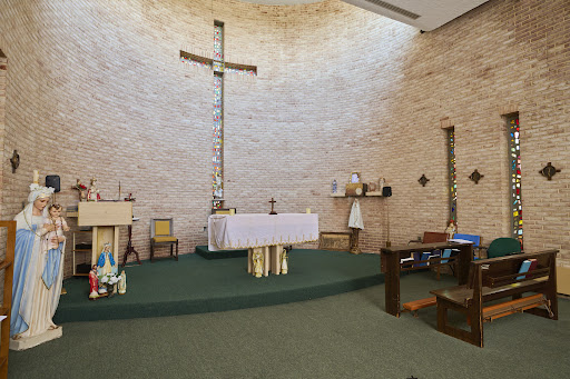 A serene view of a church altar with a prominent cross and minimalist decor.