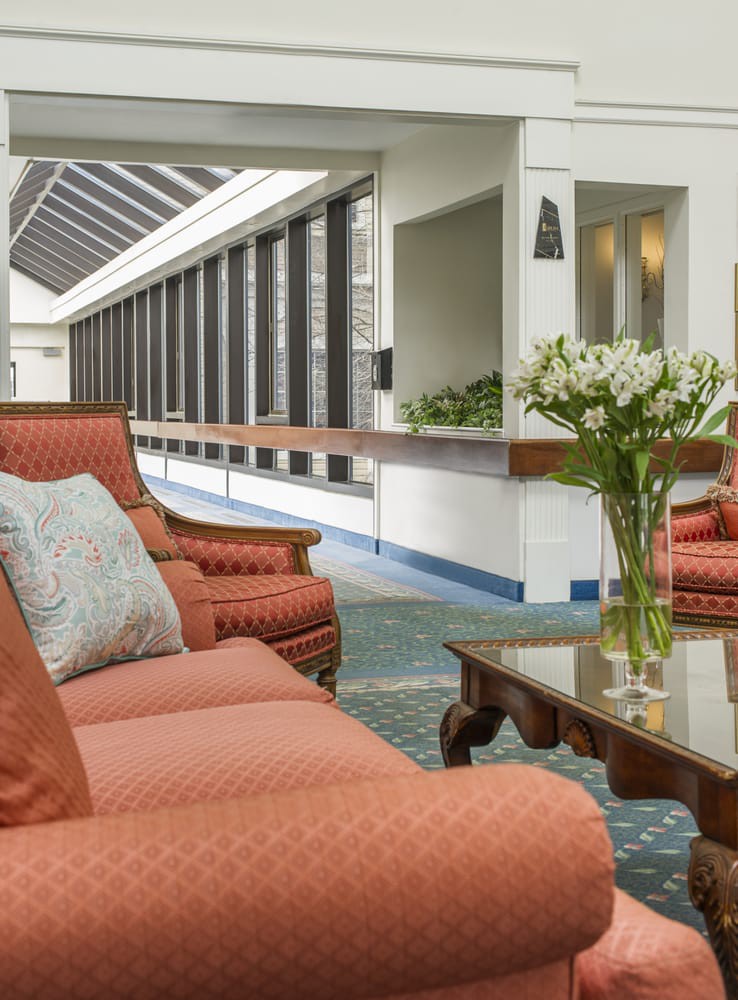 A modern lobby area featuring comfortable sofas, a coffee table, and a vase of flowers.