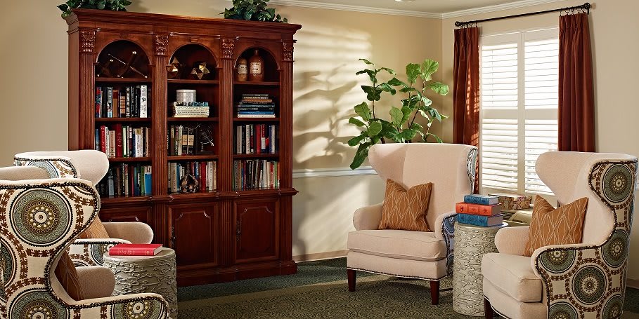 A cozy living room with a bookshelf and a comfortable armchair.