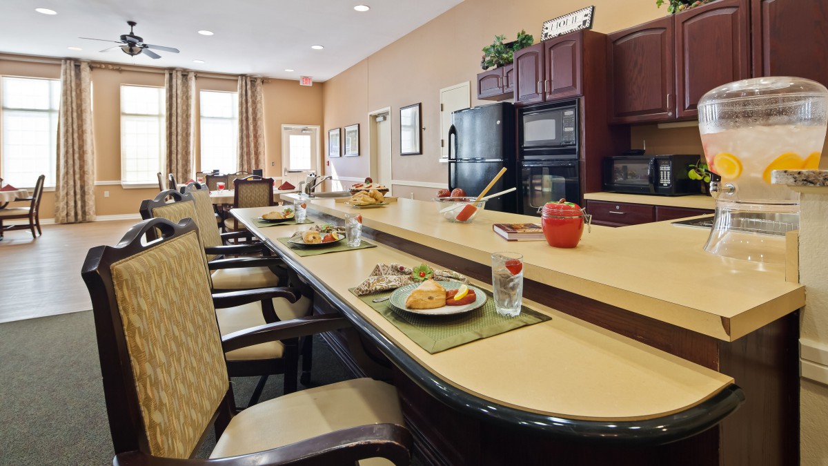 A spacious kitchen and dining area with neatly arranged chairs and a table set with meals.