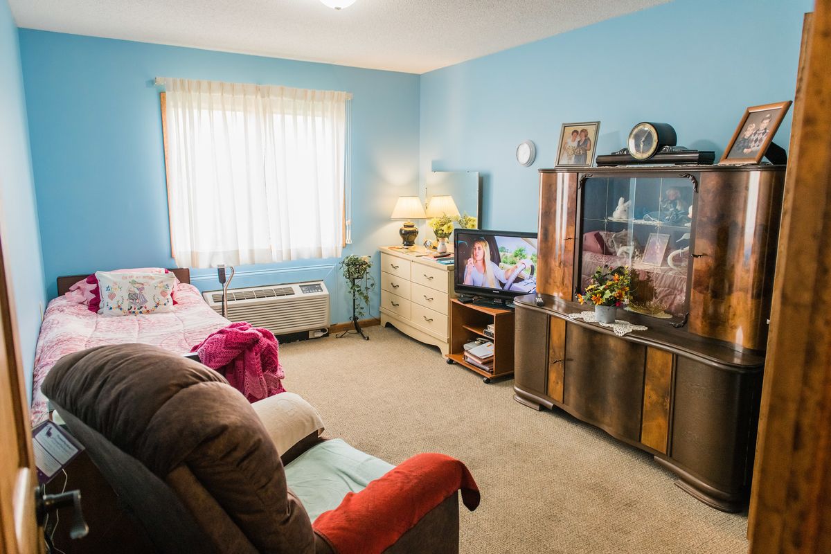 A cozy living room with a sofa, television, and natural light from a window.