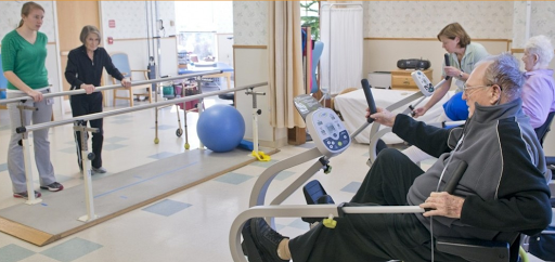 A patient using a stationary bike for rehabilitation in a physical therapy setting.