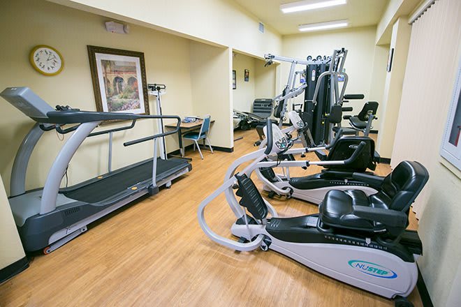 A small gym with various fitness equipment and exercise machines.