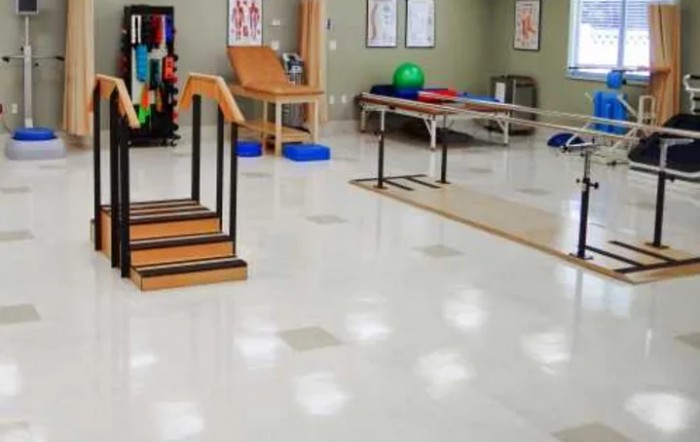 A physical therapy room equipped with exercise equipment for rehabilitation and fitness training.