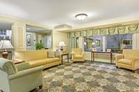 A cozy living room with comfortable seating, stylish lighting, and a patterned carpet.