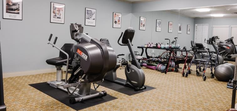 A well-equipped gym with various exercise machines and weights.