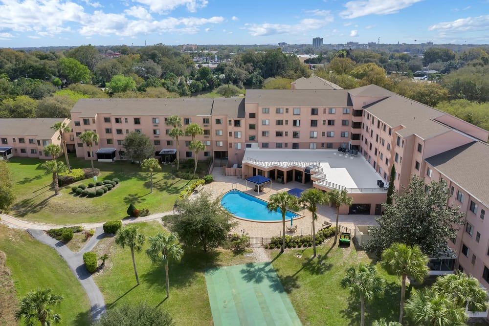 Aerial view of a hotel with a swimming pool and surrounding gardens.