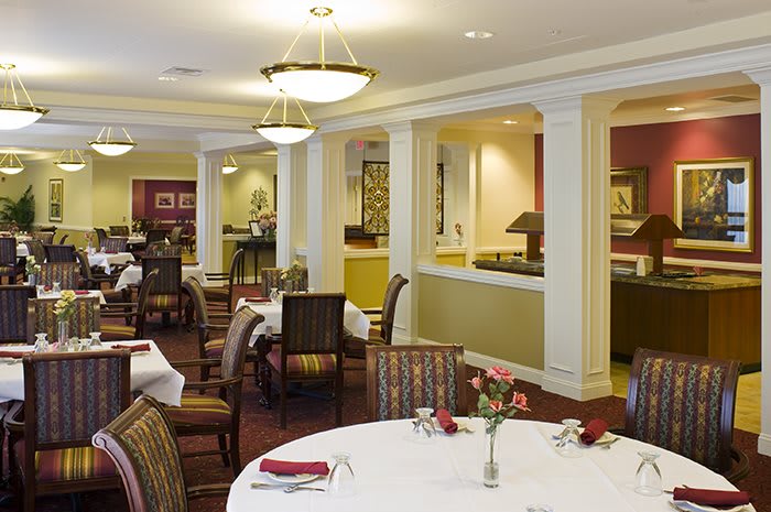 An elegant dining room interior with neatly arranged tables and chairs.