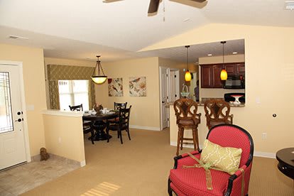 Open-concept living space with a dining area and kitchen featuring bar stools.