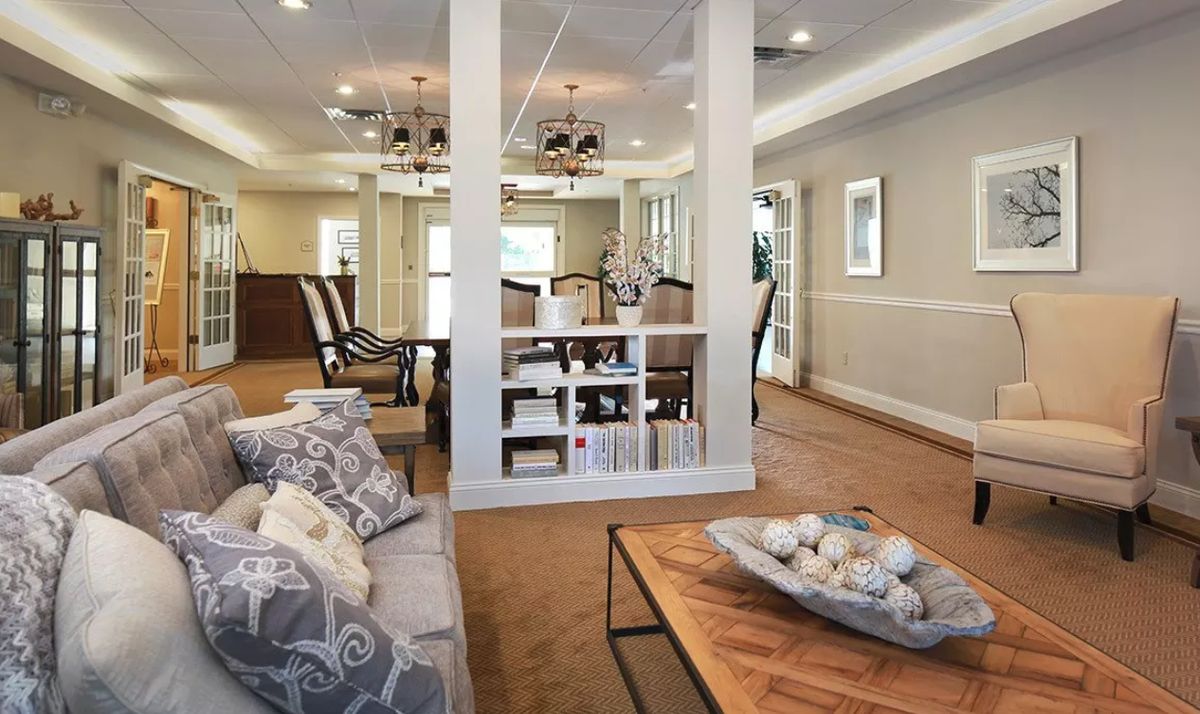 A cozy living room with a sofa, coffee table, and an adjacent dining area.