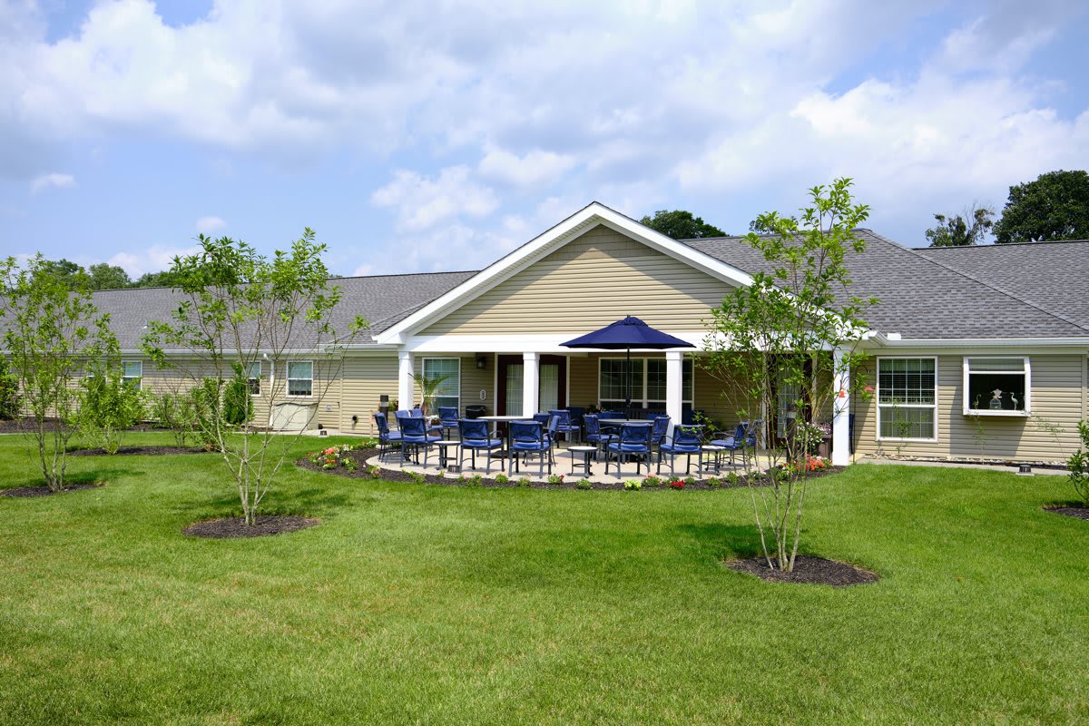A modern house with a spacious backyard featuring a patio and outdoor seating area.