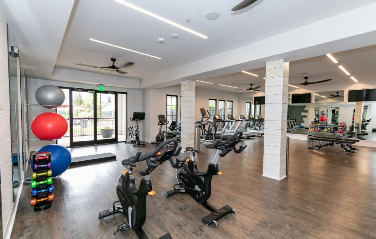A modern gym with various exercise equipment and stationary bikes.