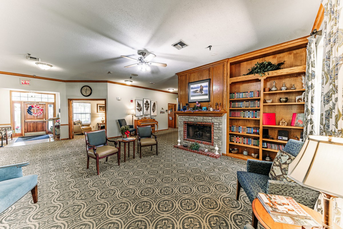A cozy living room featuring a fireplace, bookshelves, and comfortable seating.