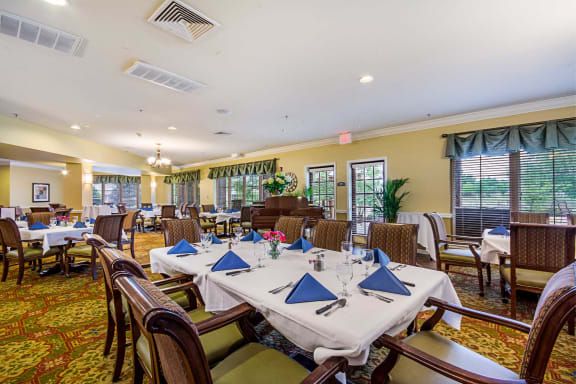 An elegantly set dining room with neatly arranged tables and chairs.