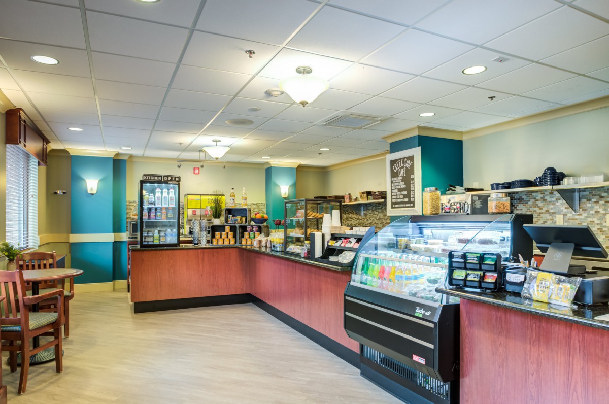 A cozy cafe interior with a service counter and beverage display.