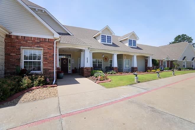 A suburban residential house with a well-maintained front yard and brick facade.