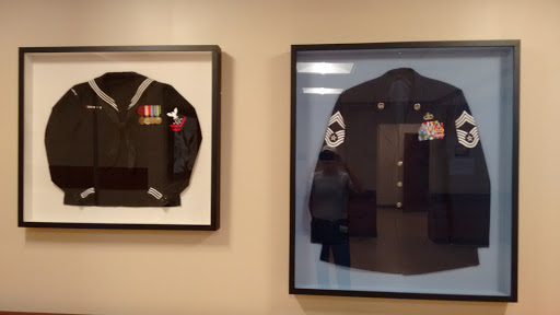 Framed military uniforms displayed on a wall, showcasing historical attire.