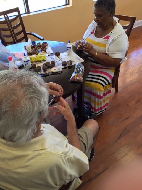Two people sitting at a table, engaged in conversation, surrounded by food items.