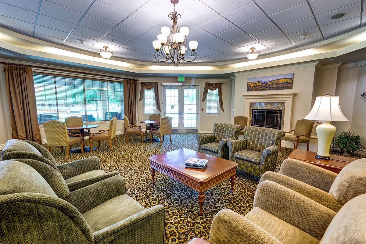 A cozy living room area with comfortable seating, a central coffee table, and a chandelier.