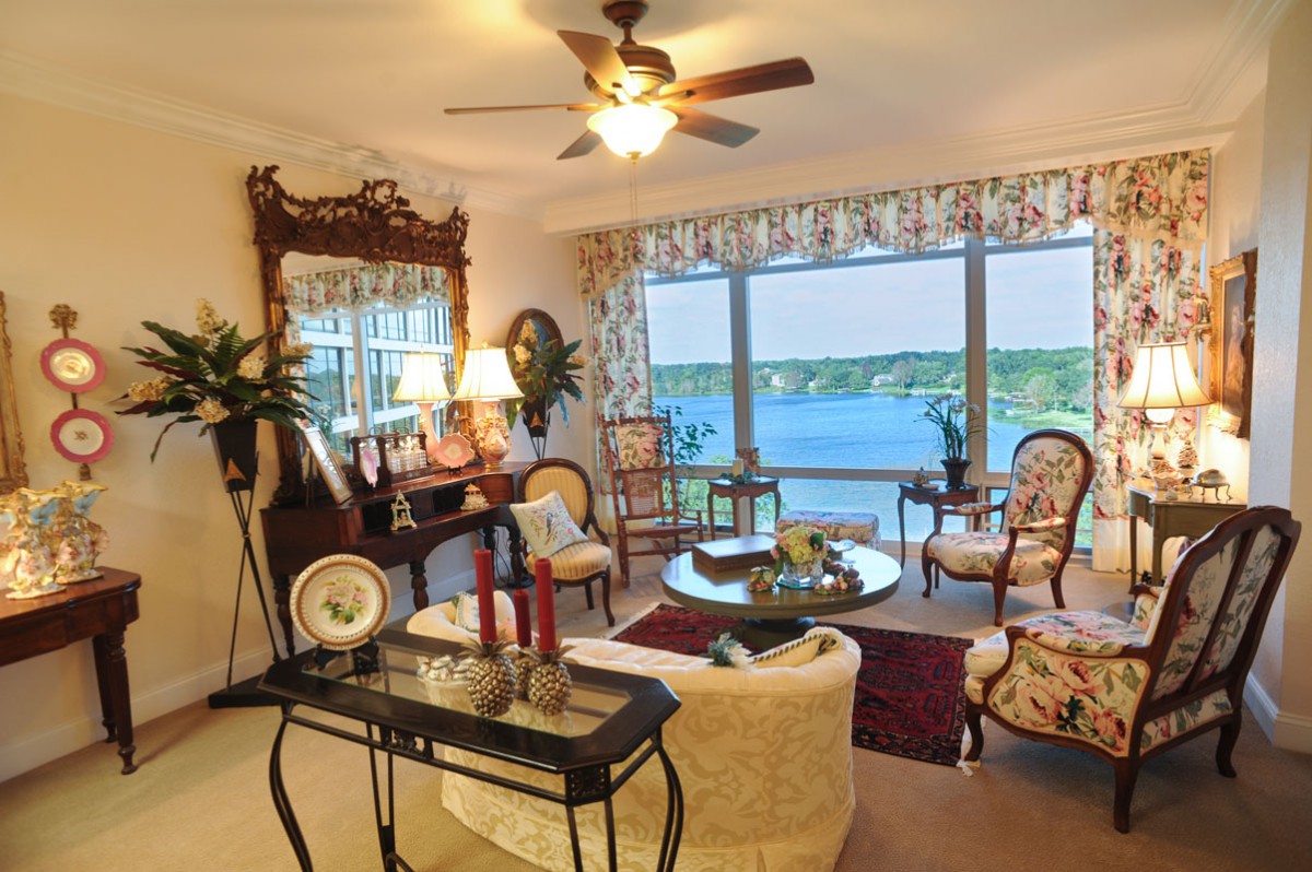 A cozy living room with vintage decor and a stunning lake view through large windows.