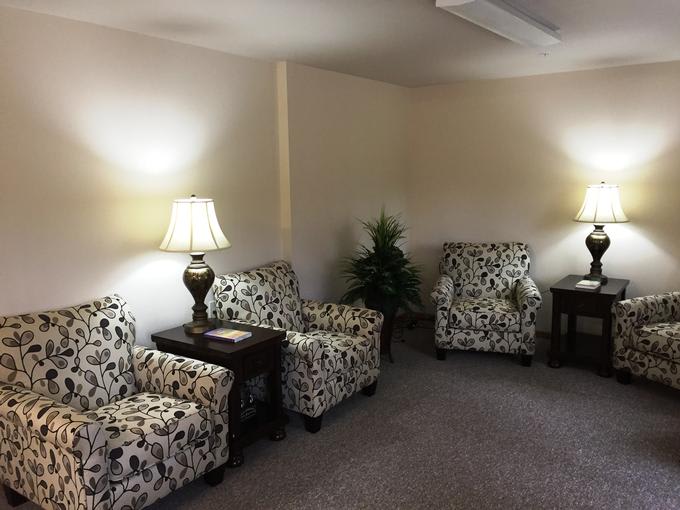 A cozy living room with patterned chairs and warm lighting.