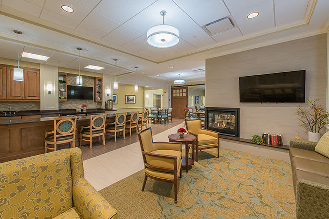 A modernly designed lounge area with comfortable seating, a fireplace, and a television.