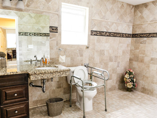 An accessible bathroom featuring tiled walls and necessary supports for convenience.