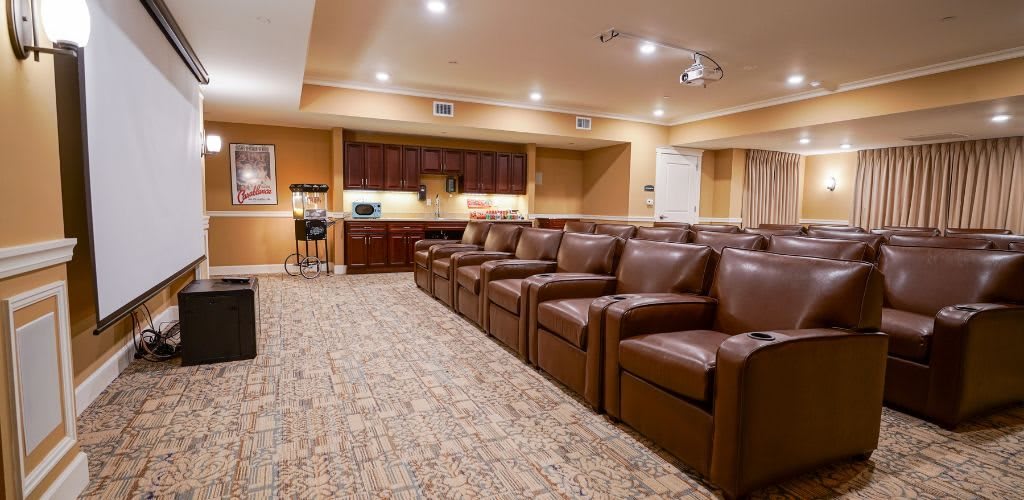 A cozy home theater room with leather seating and ambient lighting.