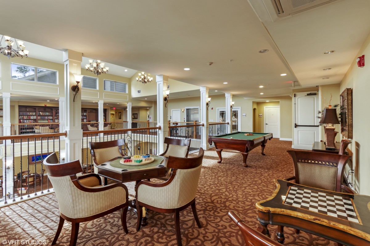 A spacious and elegant lounge area with seating arrangements and a billiards table.