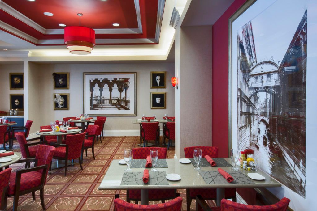 A stylish restaurant interior featuring red decor and elegant artwork.